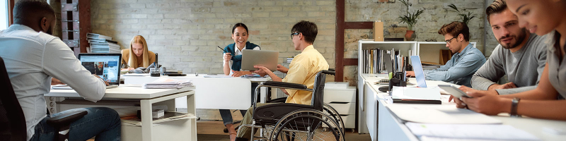 Man in wheelchair consults with coworker